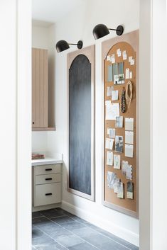 a kitchen with two bulletin boards on the wall next to a counter top and cabinets