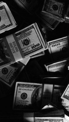 black and white photograph of stacks of one hundred dollar bills