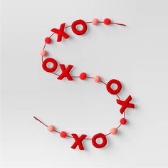 the letters xo and o are spelled with red beads on a string that is strung in two rows