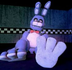 a cartoon rabbit sitting on top of a table next to a giant hand with the fingers up