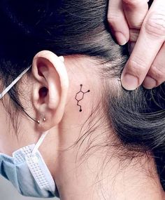 a woman with a small tattoo on her ear