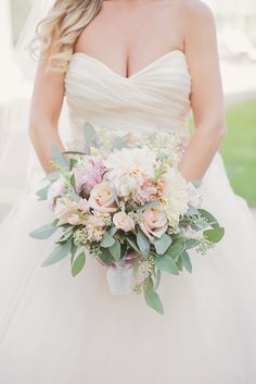 a bride holding a bouquet of flowers in her hands