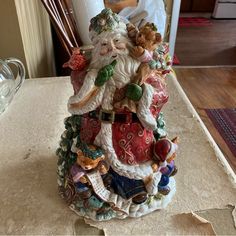 a santa clause figurine sitting on top of a counter next to a vase