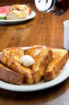 french toast is being drizzled with syrup and ice cream on a plate