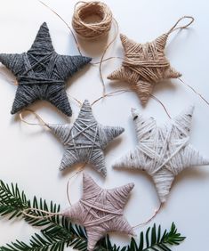 three star ornaments are hanging from twine