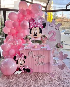 a minnie mouse birthday party with balloons and decorations