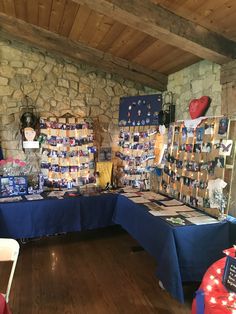 a room filled with lots of blue tables covered in cards and pictures next to a stone wall