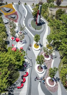 an aerial view of a park with lots of trees and people walking on the walkway