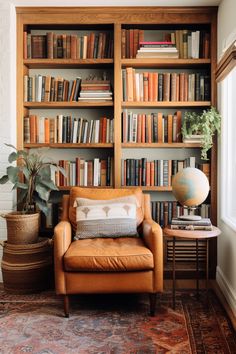 a leather chair sitting in front of a book shelf filled with books