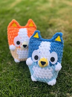 two small crocheted animals sitting in the grass