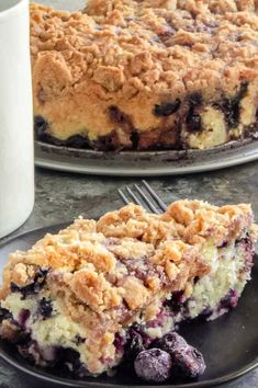 a slice of blueberry crumb coffee cake on a black plate with a fork