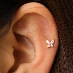 a close up of a person's ear with two small flowers on it