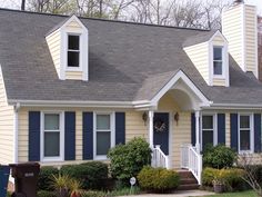 a yellow house with blue shutters and white trim