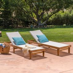 two chaise lounge chairs sitting on top of a patio