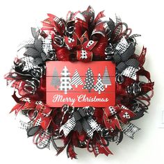 a red and black christmas wreath on a white wall