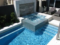 an outdoor swimming pool with blue water and steps leading up to the side of it