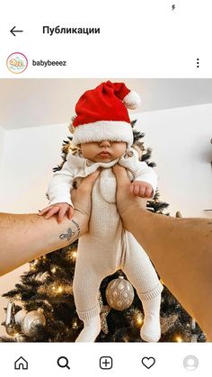 a baby wearing a santa hat is being held by someone