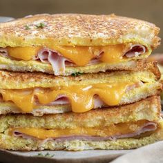 two grilled cheese sandwiches stacked on top of each other with ham and cheddar