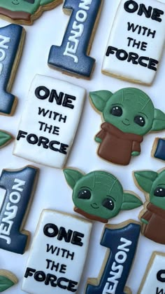 star wars decorated cookies are displayed on a white tablecloth with the words, one with the force and one with the force