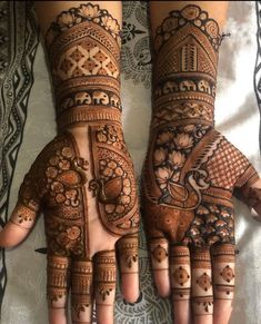 two hands with henna designs on them