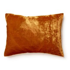 an orange velvet pillow on a white background