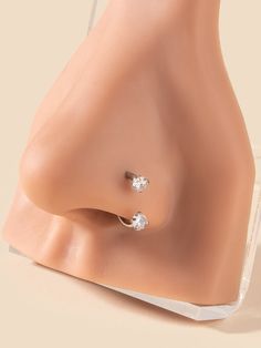 a pair of nose piercings on top of a plastic mannequin