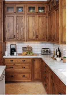 a kitchen with wooden cabinets and marble counter tops