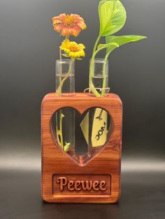 two vases with flowers in them and the words peewee are cut out of wood