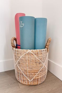 three yoga mats in a basket on the floor