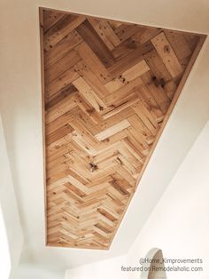 the ceiling is made from wood planks and has a herringbone pattern on it