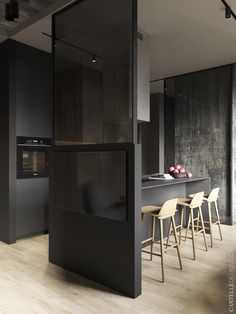 an open kitchen with black cabinets and bar stools