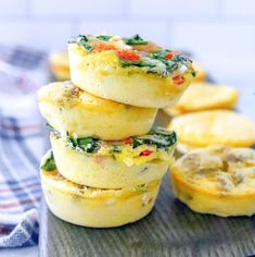 several small muffins are stacked on top of each other with spinach and cheese