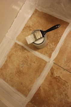 a paint brush sitting on top of a tile floor