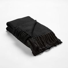 a black blanket with fringes on it