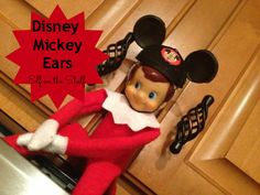 an elf is sitting in the kitchen with mickey mouse ears