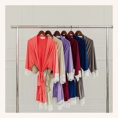 four different colored shirts hanging on a rack