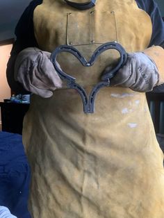 a man in an apron holding a heart shaped object