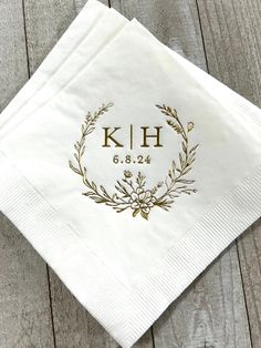 a personalized napkin on top of a wooden table with a monogrammed design