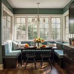 a kitchen table with two chairs and a bench in front of the window next to it