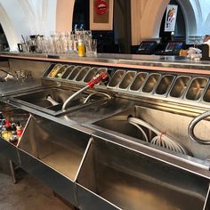 a kitchen with stainless steel sinks and lots of utensils