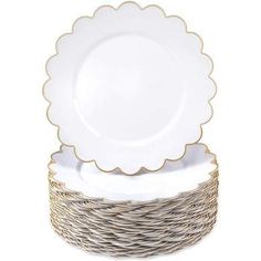 white and gold dinnerware set with scalloped rims on each plate,