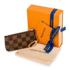 The perfect little accessory that will hold all your change while ensuring you never lose your keys again, the Louis Vuitton key pouch is one of those pieces you never knew you needed. Small but practical, this Damier Ebene pouch can fit cards, folded bills, change, little bits of rubbish that you always end up keeping - along with securing your keys on the exterior hook-clasp. A well-worthy addition to any luxury accessories collection, this LV Damier Ebene key pouch is an absolute must-have. SPL Exterior Damier Ebene canvas Gold tone hardware Chain with hook for keys Zip close Brand New condition Interior Brown canvas Mini single compartment Louis Vuitton embossed logo Brand New condition Comes with dustbag and box SPL Height 6.5cm Width 12cm Retro Boys, Lv Damier Ebene, Louis Vuitton Key Pouch, Key Pouch, Card Case Wallet, Louis Vuitton Brown, Louis Vuitton Accessories, Louis Vuitton Wallet, Louis Vuitton Damier Ebene