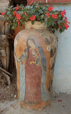 a vase with flowers in it sitting next to a building