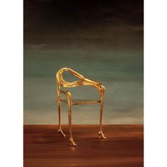 a golden chair sitting on top of a wooden floor in front of a dark sky