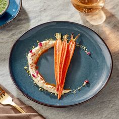 a blue plate topped with food on top of a table next to a fork and knife