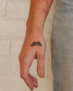 a person with a small tattoo on their left hand