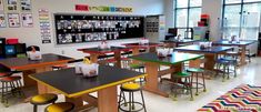 an empty classroom with tables and stools