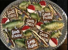 a plate that has some cookies on it with fishing related items in the shape of fish