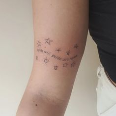 a woman's arm with stars and writing on it