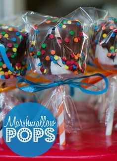 marshmallow pops with chocolate frosting and sprinkles are on a red tray